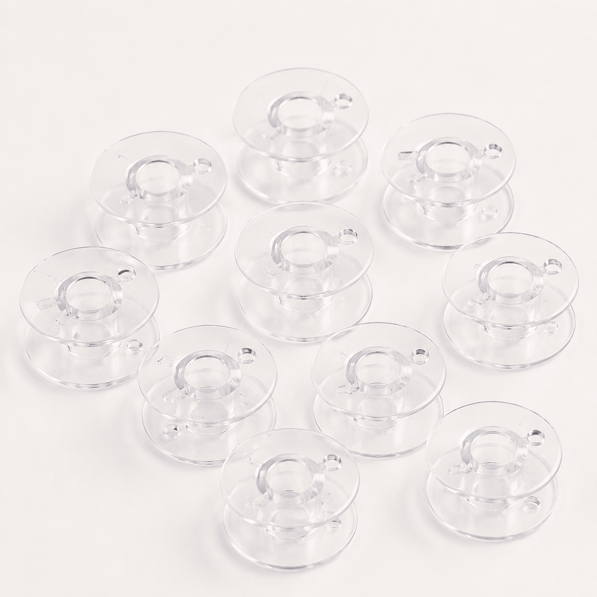 Image of flat plastic bobbins for sewing machines Ø 20.4 mm, set of 10 – available online at Šarlotes audumi