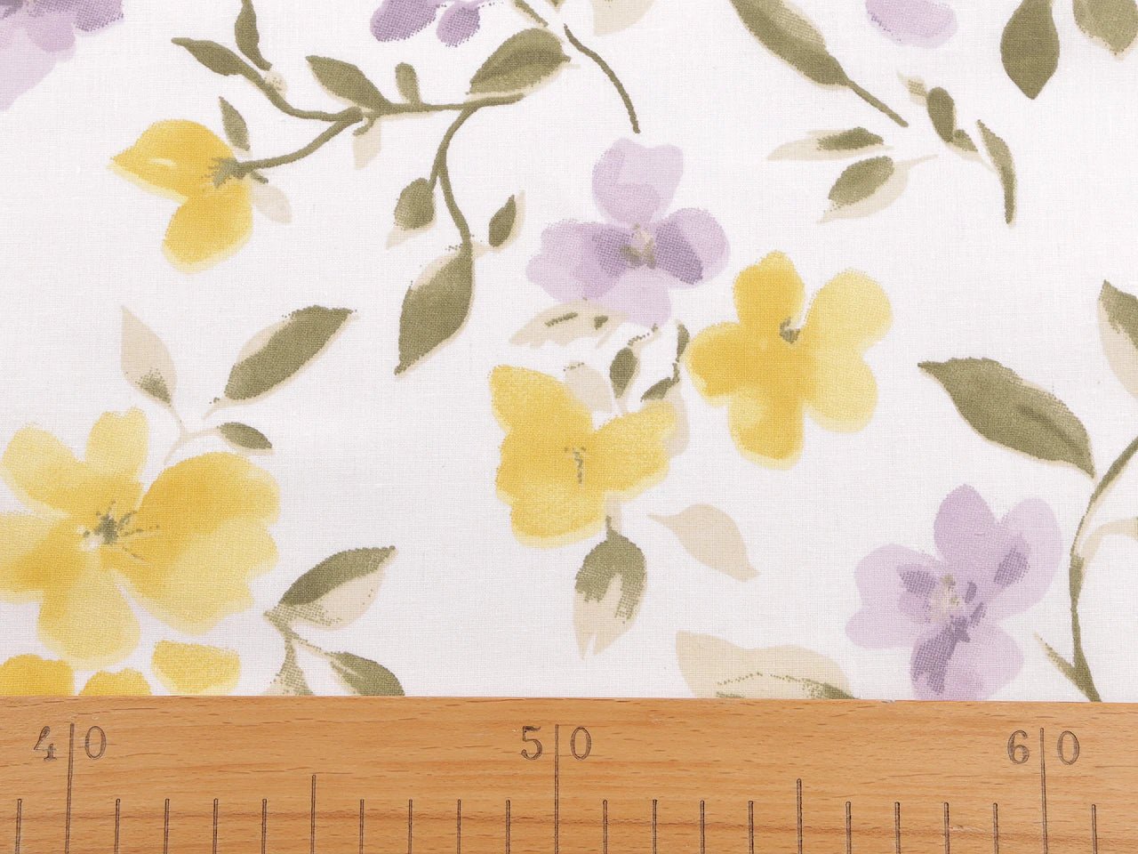 Image avec tissu 100 % coton, fleurs jaunes et lilas – disponible en ligne chez Šarlotes audumi