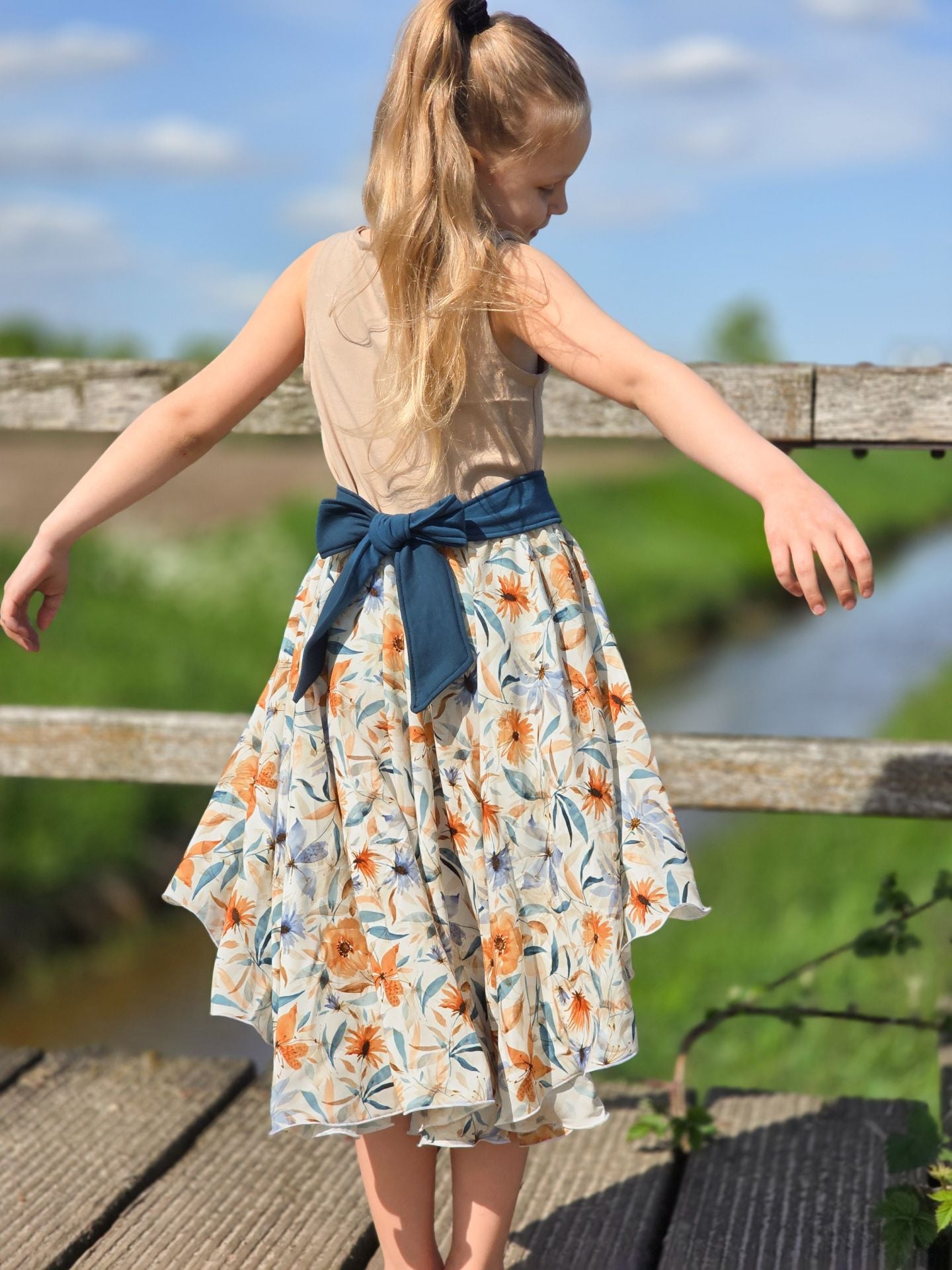 Bild mit 100 % Viskosestoff – blaues und orangenes Blumenmotiv, online erhältlich bei Šarlotes audumi
