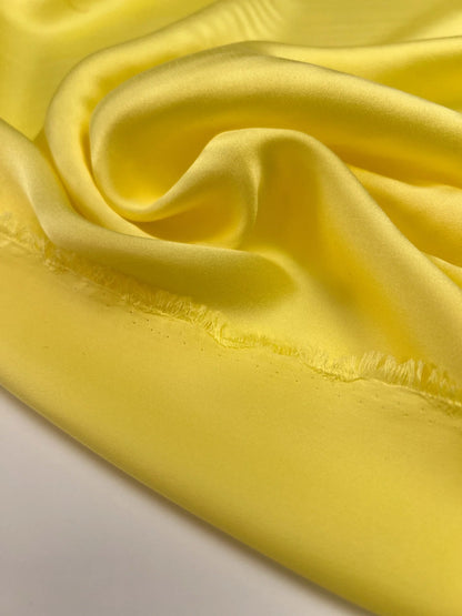 Image of 100% silk satin fabric in yellow – Italy, with a small defect – available online at Šarlotes audumi