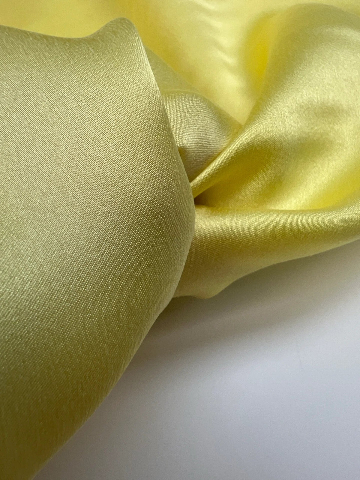 Image of 100% silk satin fabric in yellow – Italy, with a small defect – available online at Šarlotes audumi