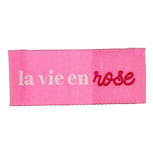Bohin sew-in clothing labels “La vie en rose” — look at life through rose-colored glasses — 2 × 5 cm, 4 pcs — available online at Šarlotes audumi