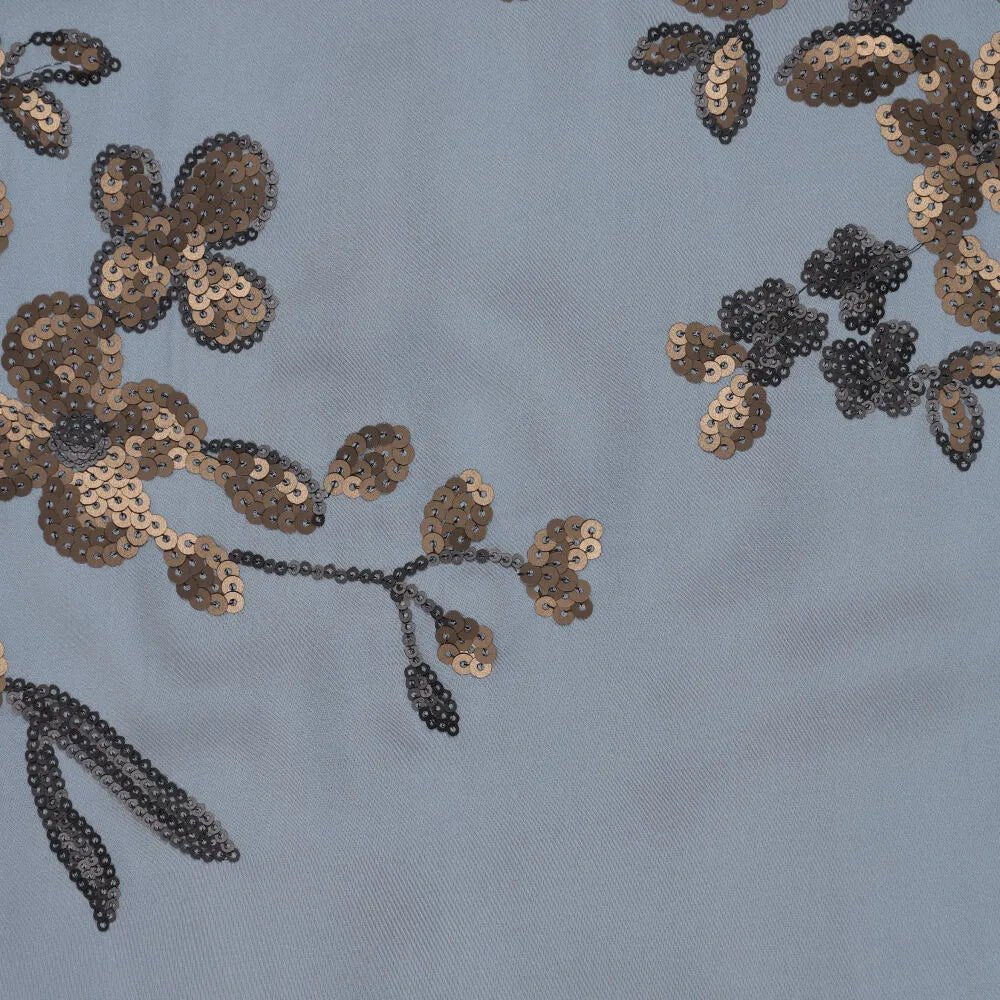 Tissu satiné extensible avec broderie florale et paillettes bleues, noires et dorées, disponible en ligne chez Šarlotes audumi