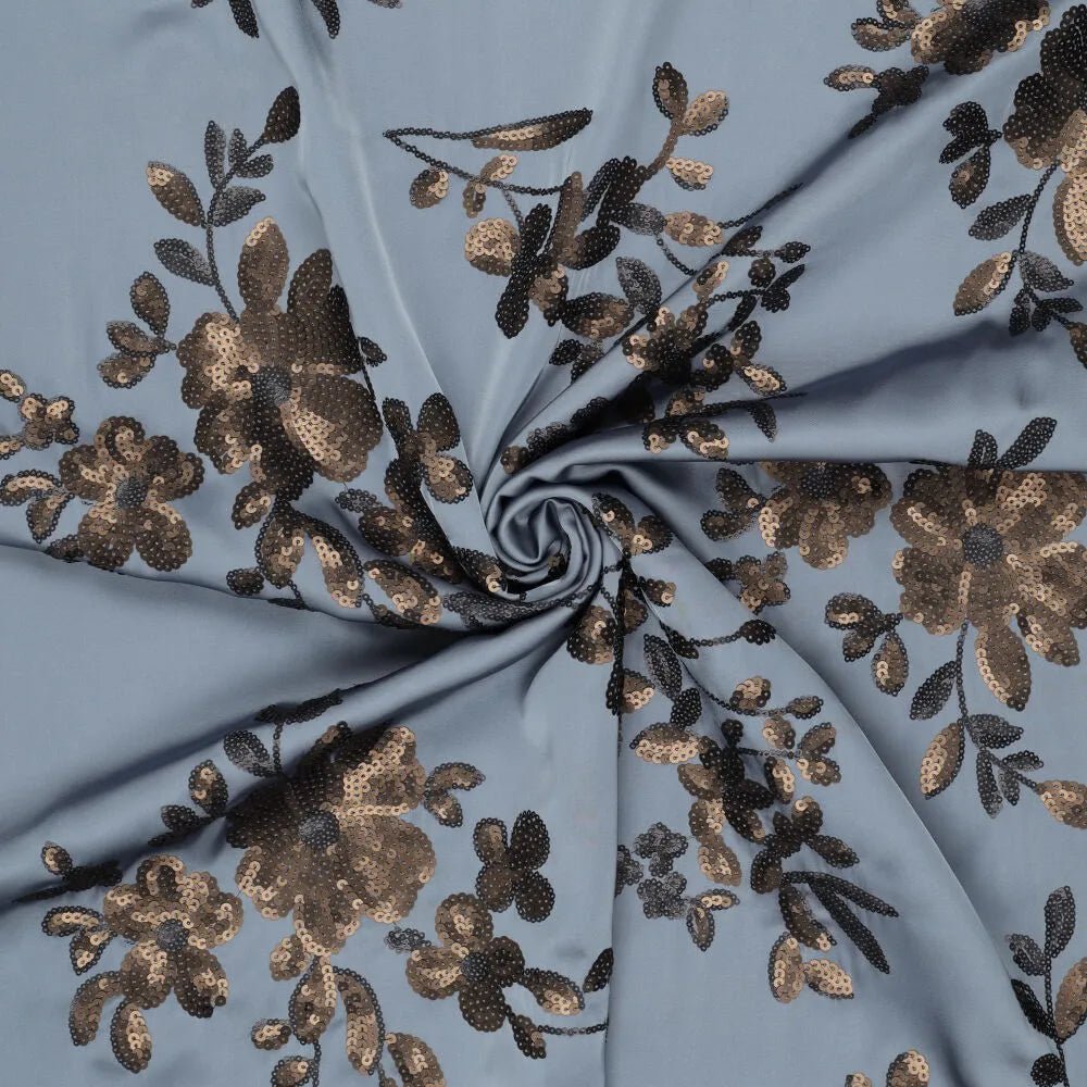 Image de tissu satin extensible avec broderie florale et paillettes bleu, noir et doré – disponible en ligne chez Tissus Charlotte