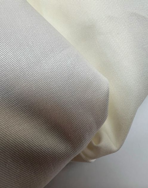 Image d'un tissu italien en coton et élasthanne blanc ivoire 150 g/m2 – disponible chez Šarlotes audumi