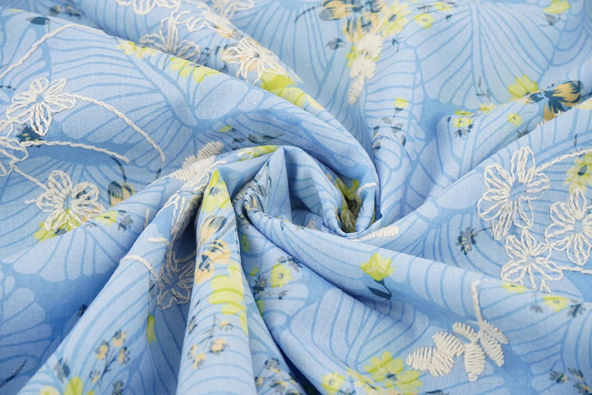 Image de tissu en coton brodé - fleurs jaunes sur fond bleu 115 g/m² – disponible chez Šarlotes audumi