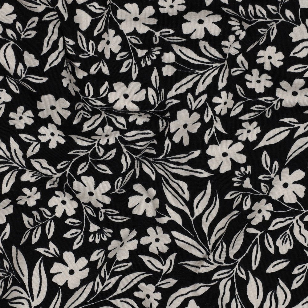 Image with cotton knit fabric - white flowers on black 200 g/m² – available at Charlote's Fabrics
