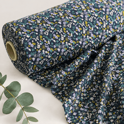Image of cotton jersey with delicate flowers on a dark blue background – available online at Charlotte’s Fabrics