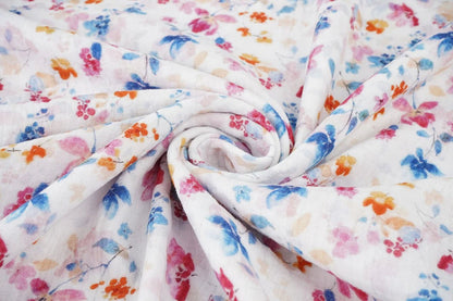 Image d’un tissu en mousseline à fleurs bleues et roses – disponible en ligne chez Šarlotes audumi