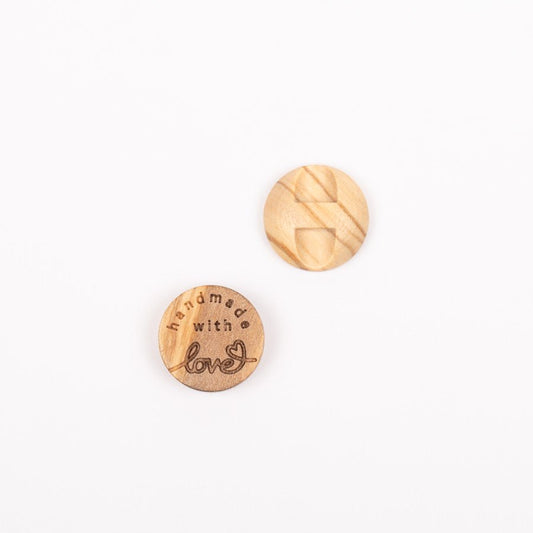 Image of an olive wood button, “Handmade with love,” 15 mm – available online at Šarlotes audumi