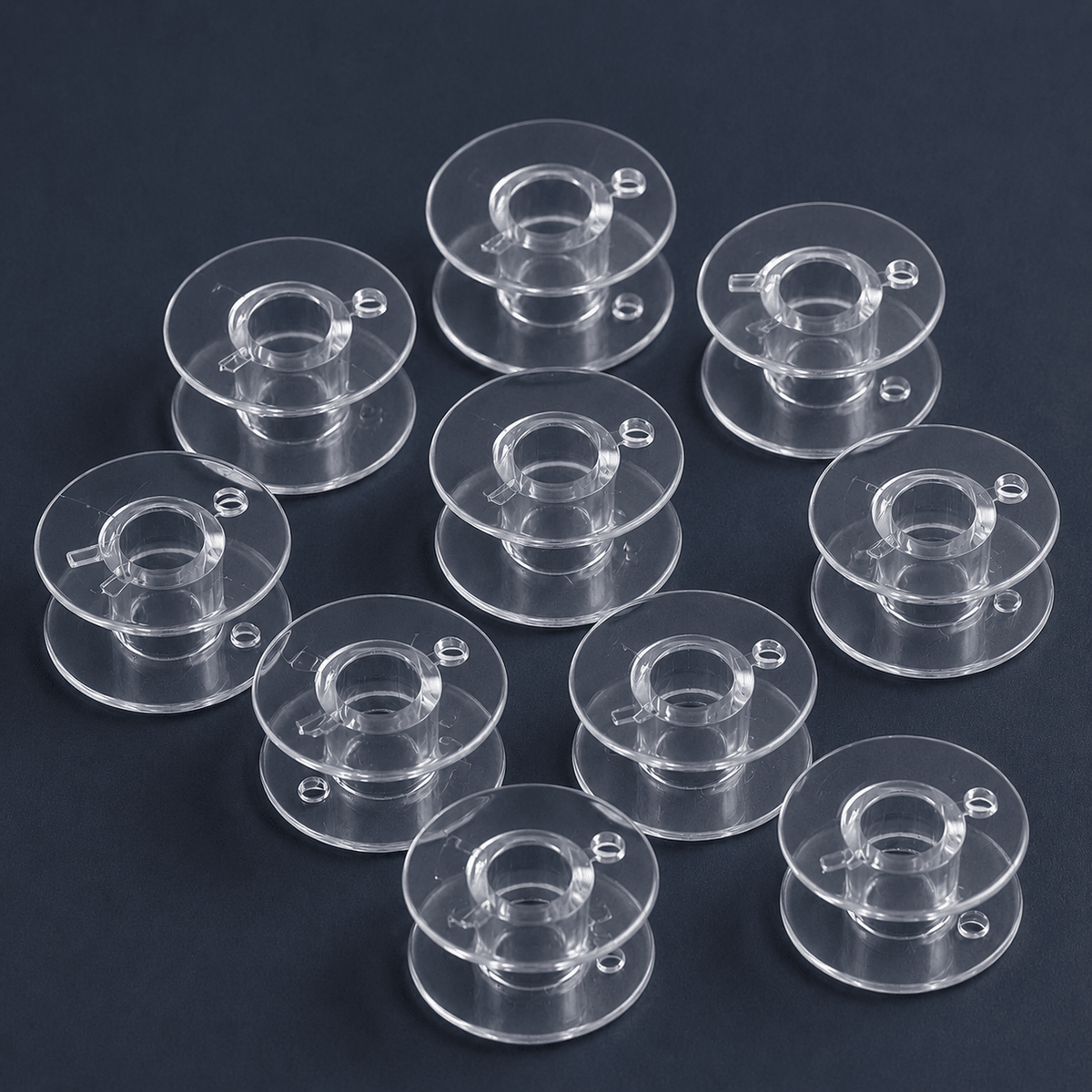 Image of flat plastic bobbins for sewing machines Ø 20.4 mm, set of 10 – available online at Šarlotes audumi