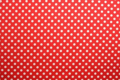 Image of poplin dots on a red background – available online at Šarlotes audumi