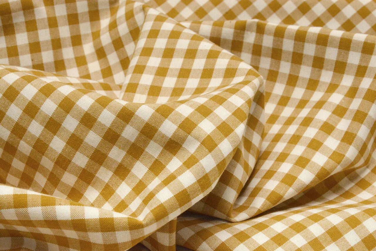 Image de tissu en coton premium à carreaux jaune moutarde, disponible en ligne chez Šarlotes audumi