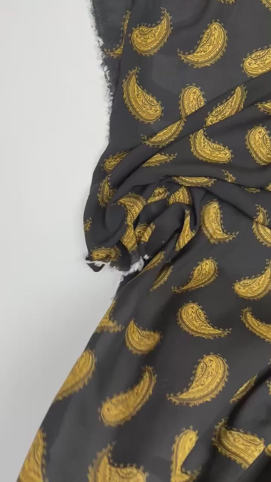 Tissu en mousseline 100 % viscose italienne, motif paisley doré sur fond noir – 100 g/m²