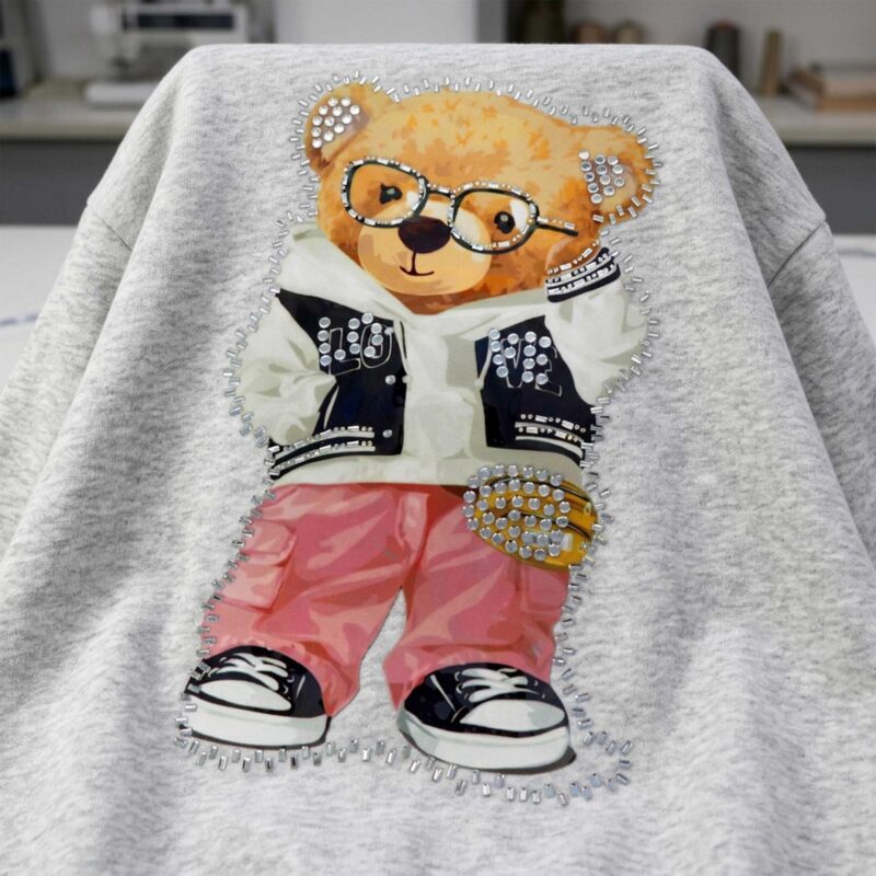 Image with thermal appliqué “Teddy Bear with Glasses” – 29 × 17 cm – available online at Šarlotes audumi