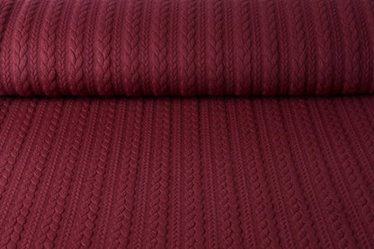 Image d’un tissu en maille à motif tricoté - torsades bordeaux 340 g/m² – disponible chez Šarlotes audumi