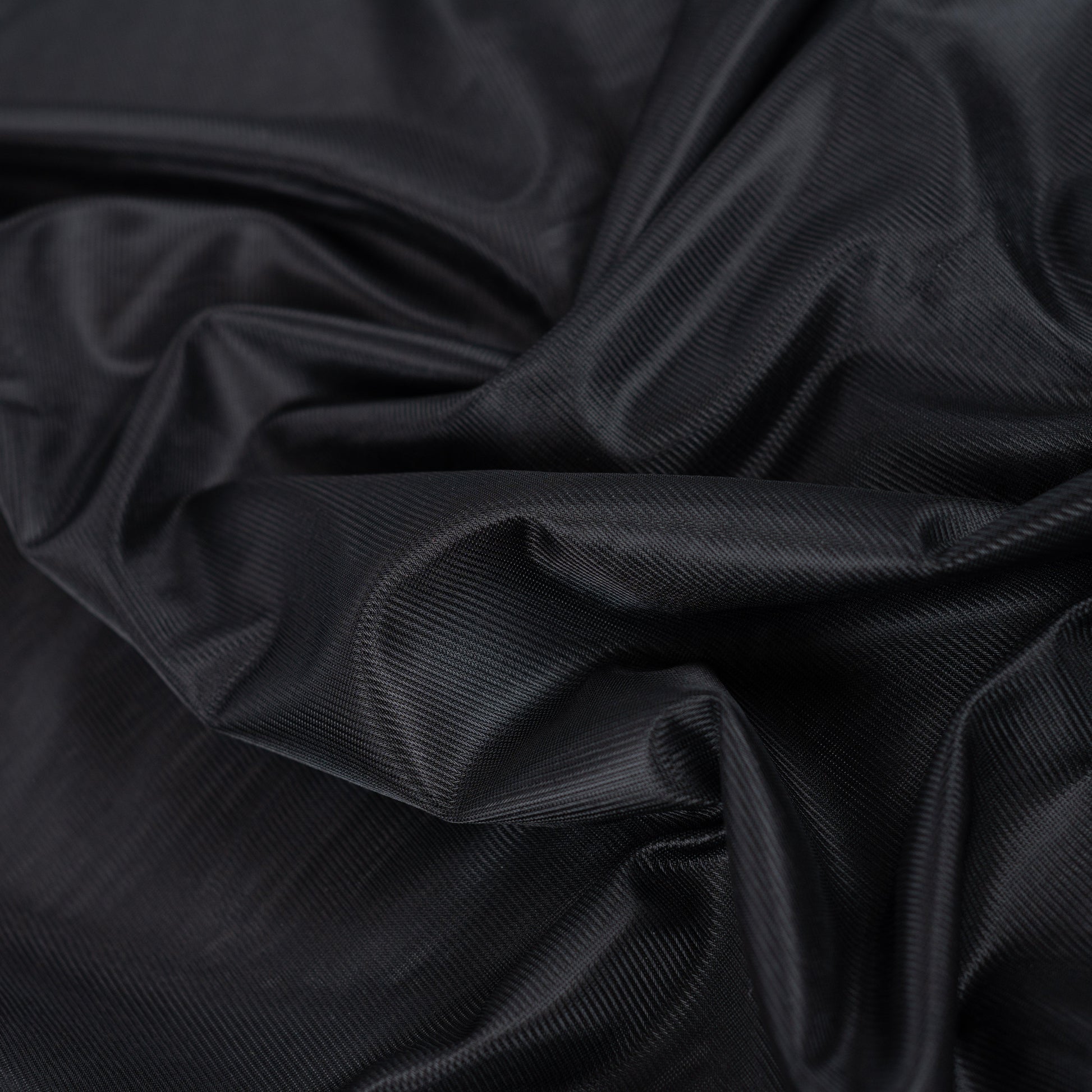 Image du tissu de doublure en maille noir – disponible en ligne chez Šarlotes audumi