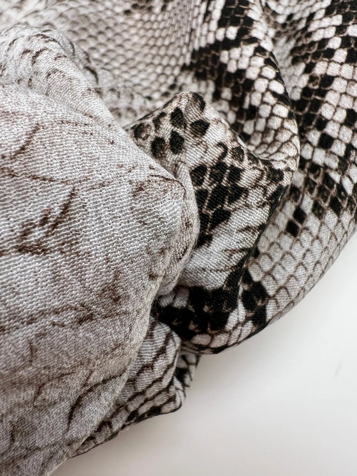 Image of viscose crepe fabric with snakeskin pattern in beige tones – Italy – available online at Šarlotes audumi